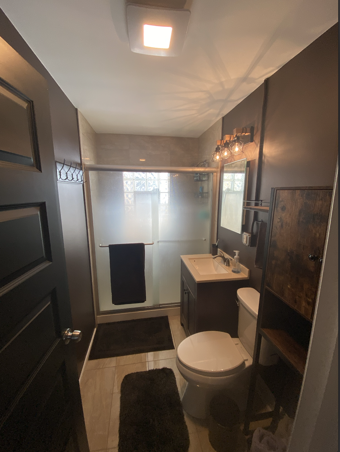 Bathroom renovation project showing new tile flooring, modern vanity, mirror installation